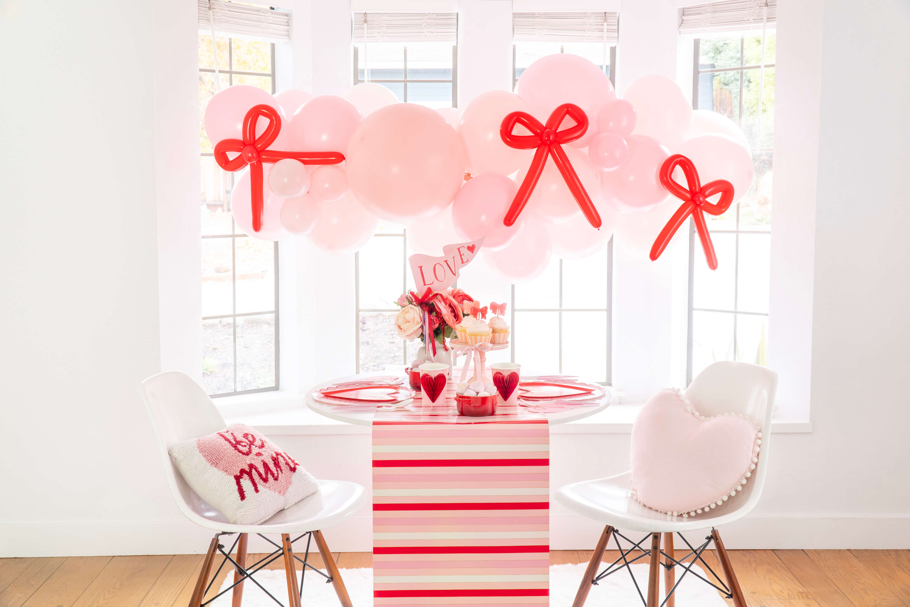 A pink and red bow themed Valentine's Day party decoration set up by Momopartys