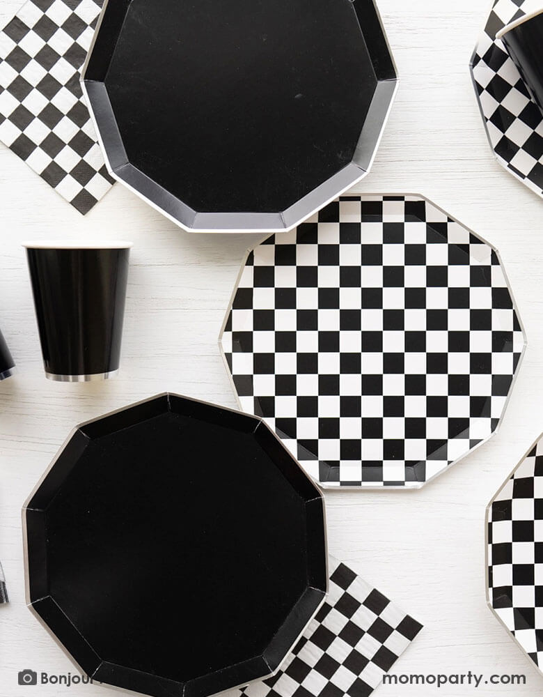 A table full of Momopartys's black themed party supplies including the 10.75" Black Noir Premium Dinner Plates, the checkered plates and napkins and the Black Noir Premium Party cups by Bonjour Fete. These elegant tablewares are chic and stylish. They are the perfect basic additions to your dinnerware collection.