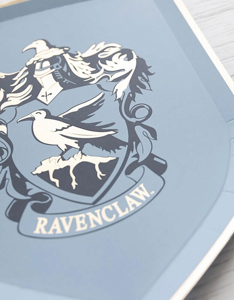 A close up shot of Momopartys's 7" Harry Potter House Pride Small Plates by Bonjour Fete. Comes in a set of 8 shield-shaped paper plates in 4 colors/designs each represent the color and symbol of the houses including Hufflepuff, Gryffindor, Slytherin and Ravenclaw. These plates are prefect for your Harry Potter themed celebration, be it a birthday party, a Halloween bash or a magic themed gathering.