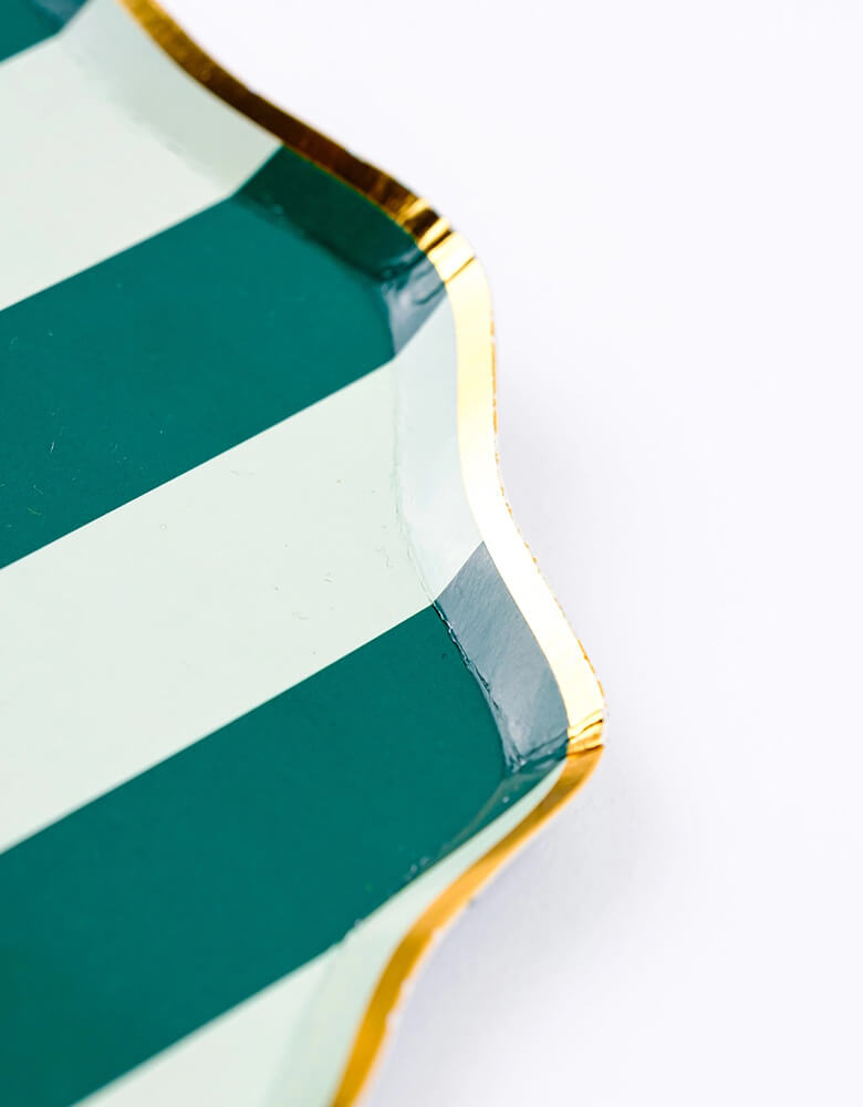 A close up shot of Momopartys's 8.5" Holiday Stripes Dessert Paper Plates by Gatherings. Comes in a set of 8 plates, made with eco-friendly FSC Mix paper, these vibrant and stylish plates with gold foil edge are the perfect addition to any holiday table, and their durable design ensures they can handle any dessert or appetizer. Make your holiday celebrations even more special with these delightful plates!