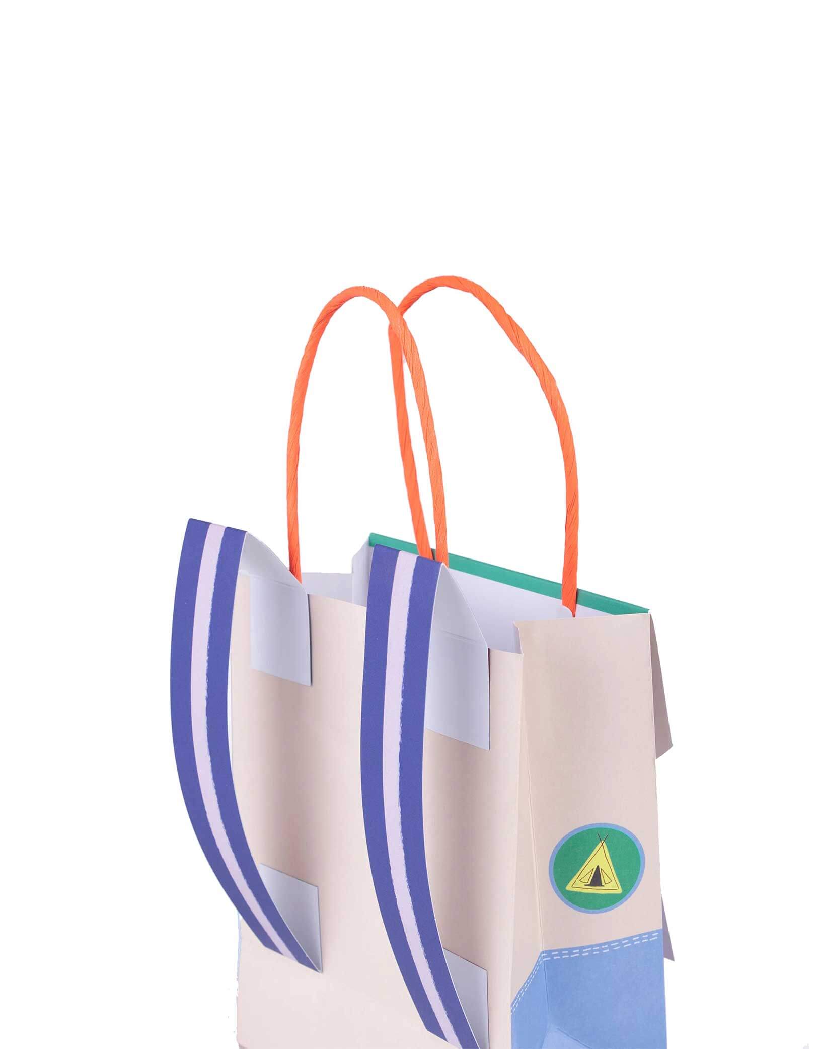 A close up of the back of Momopartys's 5 x 6.5 x 3 inches Camping Adventure Backpack Party Bag by Meri Meri. Tthis adorable camping adventure backpack party bag is the perfect choice for your kid's camping themed birthday party. After a day of yummy snacks and exploring the wild woods, send your little adventurers home with a special bag featuring retro summer-camp designs and cool backpack straps.