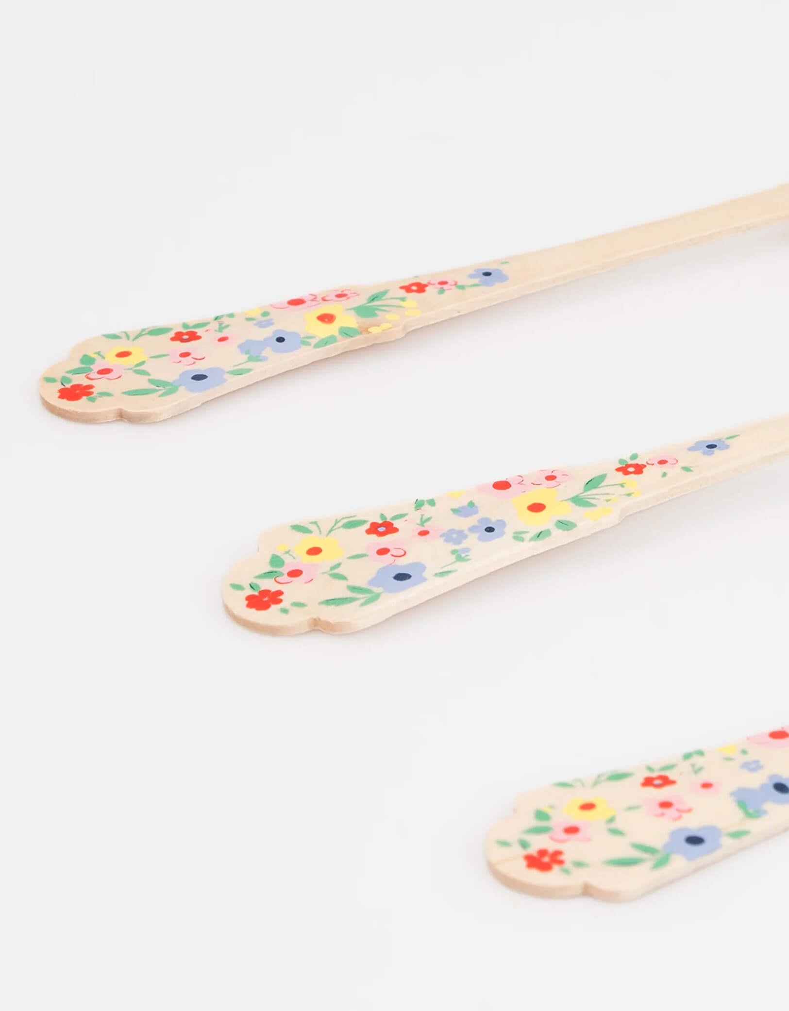 A close up shot of Momopartys's Elegant Floral Wooden Cutlery by Meri Meri. Comes in a set of 24, made of eco- friendly birchwood with sculpted handles, they are 100% biodegradable. This set features colorful floral handles for a fresh, summery look. Perfect for a garden party, Mother's Day celebration for a girl's tea party birthday celebration.