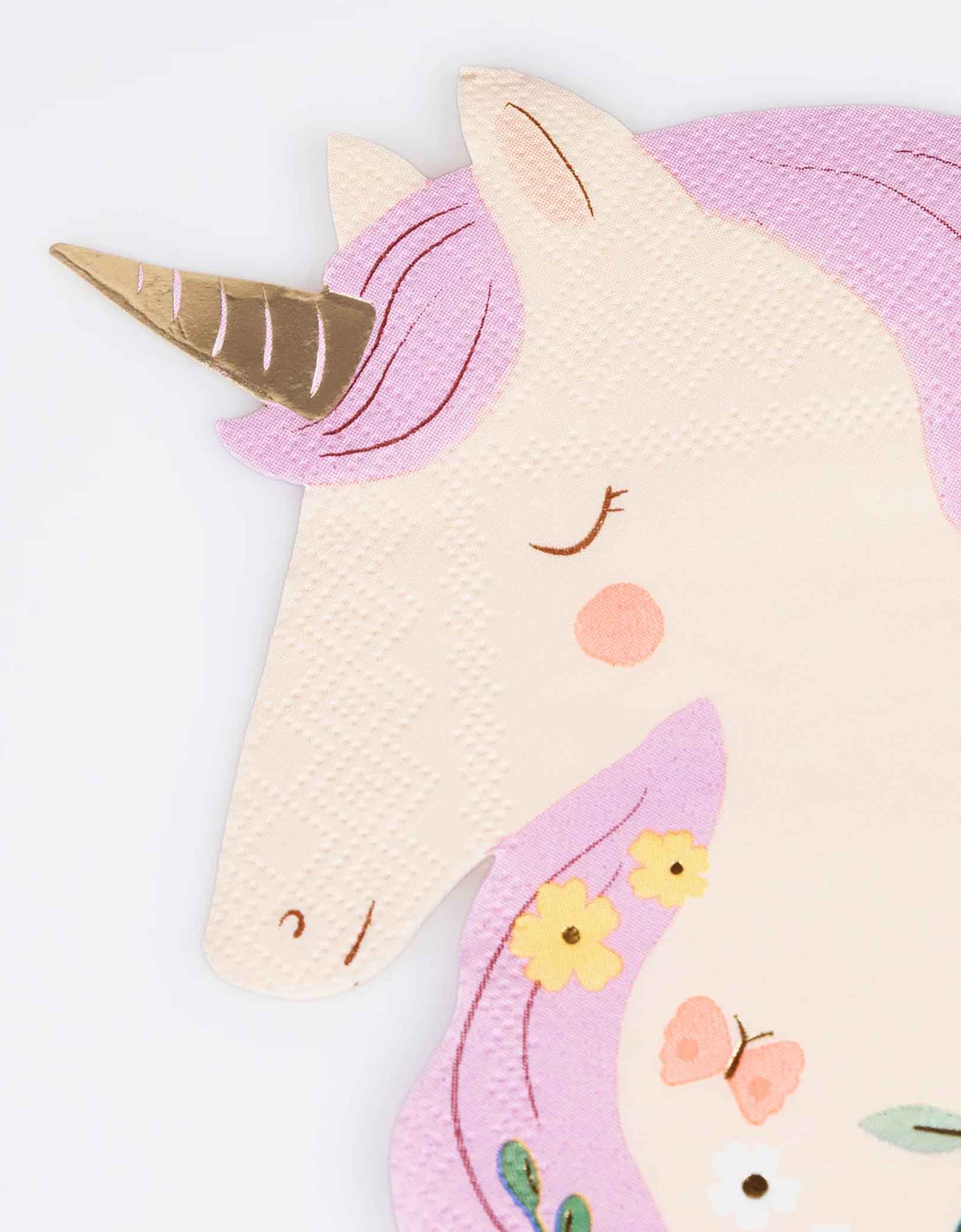 A close up shot on Momopartys's 6.25" x 6.375" Meadow Unicorns Shaped Napkin by Meri Meri. Comes in a set of 16, these pretty paper napkins will instantly make your little girl's unicorn or princess party look so magical. Great for table layering and mixing and matching with pastel tableware and decorations.