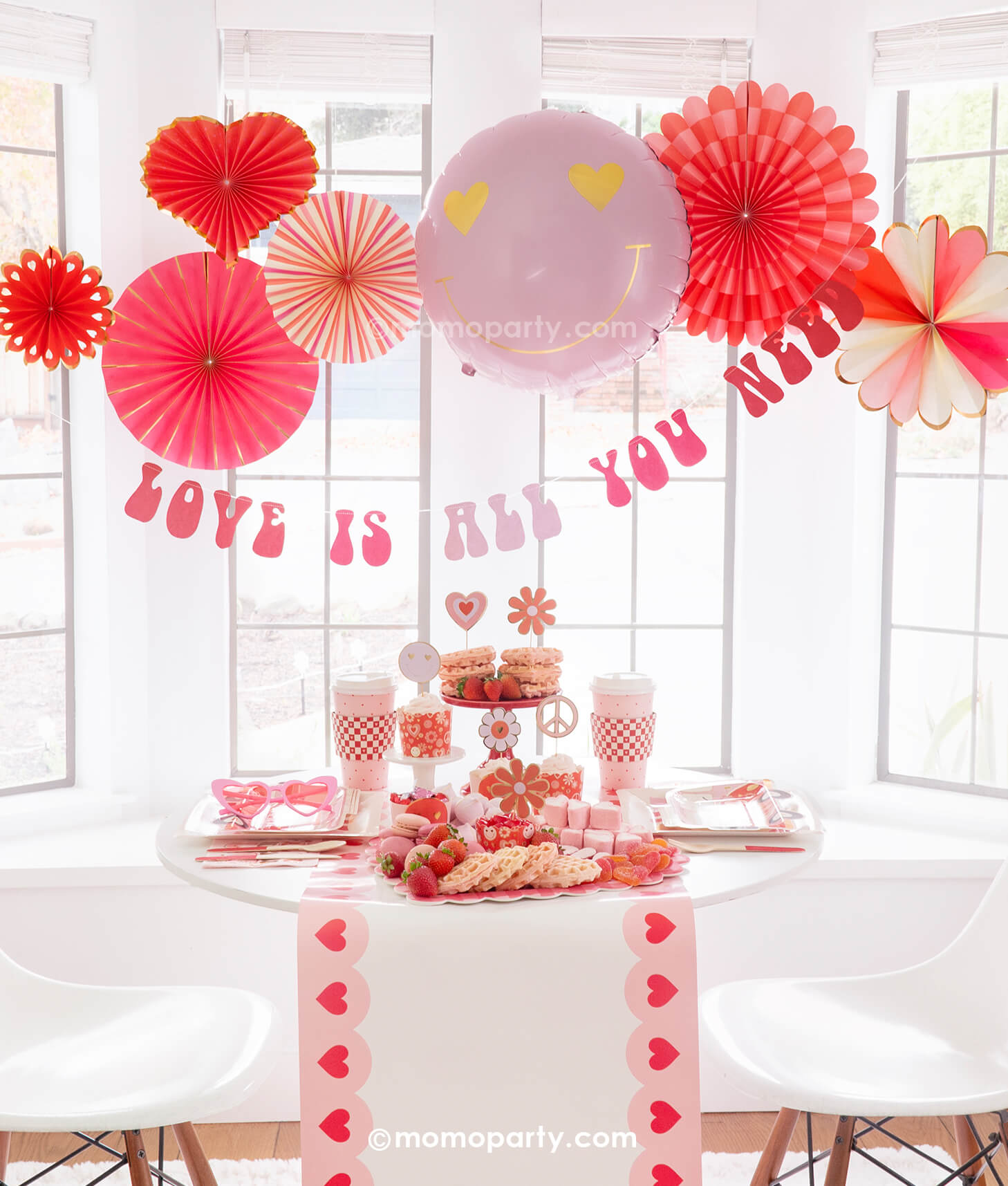 Momopartys presents the Groovy Valentine's Day Party Box, capturing a vintage vibe of love and peace with a groovy touch. This comprehensive kit includes My Mind's Eye Square Love Paper Plates, Luv Bus Paper Plates, All You Need is Love Napkins, Red Checks To-go Party Cups, Love Baking Cups With Toppers, Pink Heart Border Paper Table Runner, Heart You Paper Fan Set, Love Is All You Need Banner, and a Heart Eyes Love Foil Balloon. Perfect for throwing the ultimate Valentine's Day party