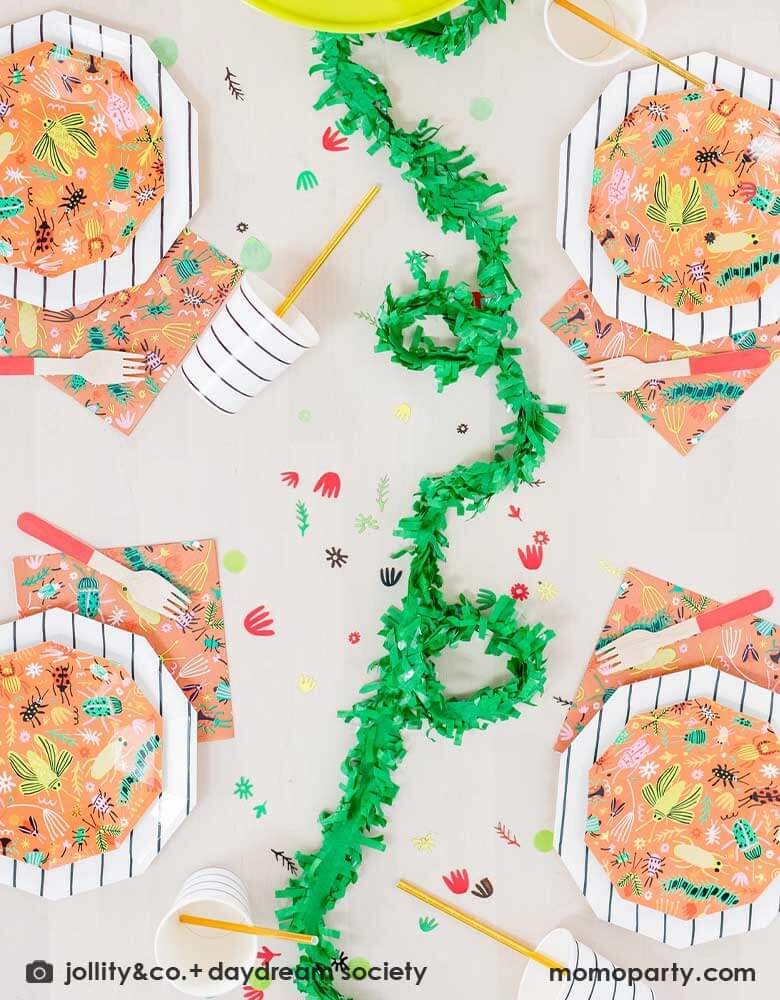 A kid's bug theme birthday party table filled with Momopartys's backyard bug themed party supplies and tableware including plates, napkins and confetti. With neon tone bugs in modern illustrations. Along with black striped plates and party cups, these bug themed partyware if perfect for your child's crawling bug inspired party!