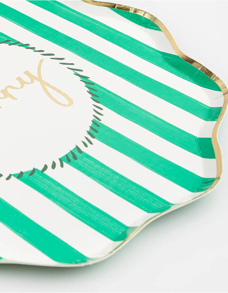 A close up at Momopartys's 10.25 x 10.25 inches Christmas striped dinner plates by Meri Meri. Come in a set of 8 in 4 different colors of red, pink, mint, and green with Jingle, Fa La LA, Merry, and Jolly words on them, these vintage inspired designs with gold foil details, with fun messages, will instantly add style to your celebrations over the holidays.
