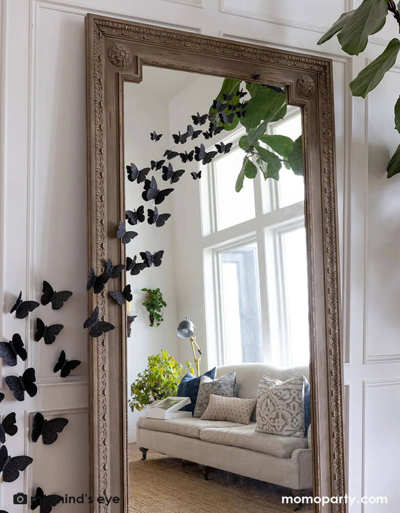 A large full body mirror decorated with Momopartys's Halloween Wall Black Glittered Butterflies Decorations by My Mind's Eye. These die cut and dimensional butterflies are the perfect way to add some fright to your home this Halloween.