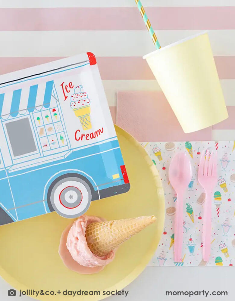 A festive party table featuring Momopartys's 10.5″ x 8″ Ice Cream Truck Plate by Daydream Society. Next to the ice cream truck plate there were a pink striped plate and napkin holding a scoop of ice cream in a waffle cone.