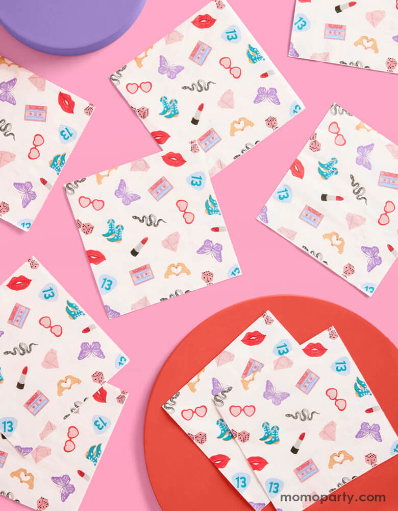 Momo Party's 5" x 5" Taylor Swift Era's Party small napkins Xo, Fetti. Comes in a set of 25 napkins, these napkins have a Taylor Swift inspired motif featuring red lipstick, red lips, butterflies, cowgirl boots, snakes, cassette tapes, guitar picks, heart hand symbols, and heart shaped sunglasses. They're perfect for the party table celebrating your Swiftie girl's special day.