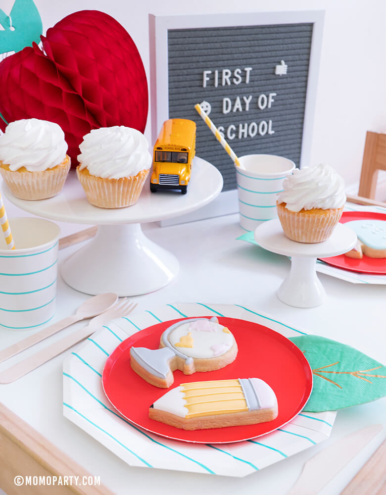 Momopartys - Modern Back To School Party Table inspiration with Oh happy day Cherry Red side plate with Meri Meri Leaf napkin represent as Apple. Aqua Striped Large Plates and cups, Leaf Napkins, Letter board with "First Day of School" sign, , Honeycomb Apple, cupcakes, and school bus toy on cake stand as tableware