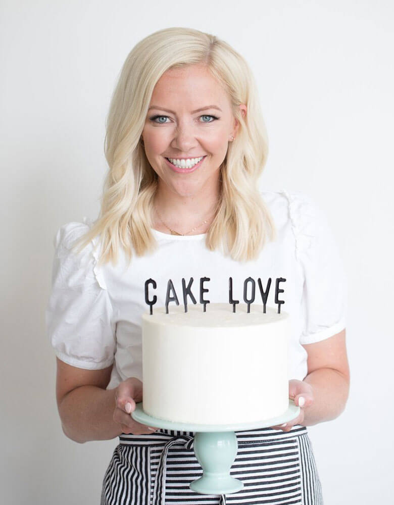 Courtney holding a cake with my mind's eye's black Letter-board Cake Toppers on it
