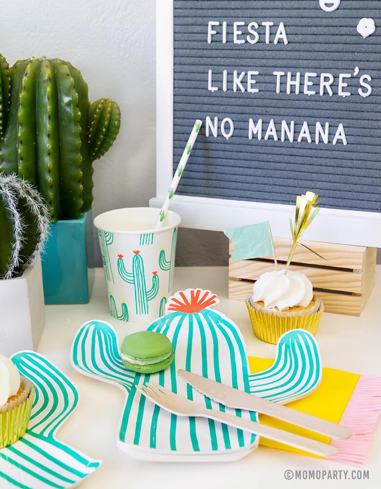 Fiesta Cactus Theme party set up dessert table with Macaron on the Cactus die-cut plates, Cactus paper cups and Cactus printed straw, cupcakes, mini cactus planter, and letter board with writing in "Fiesta Like There's No Mañana""