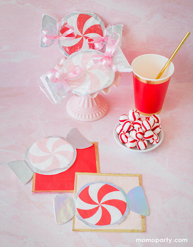 A sweet holiday dessert party inspiration with Pink and Red Peppermint Small Napkins, Posh Cocktail Napkins - Red "Ruby Kiss" color and Pink "On Wednesdays" color, peppermint, cups with gold paper straw on a pastel pink background