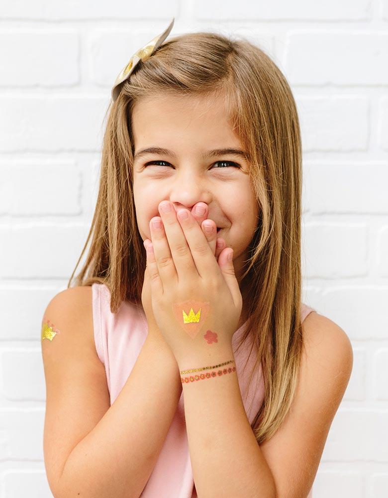 Girl waring My Minds Eye's Princess Temporary Tattoos on her arms and hand in a princess party