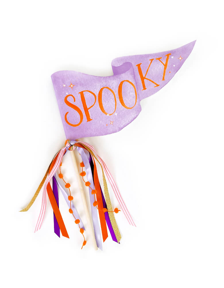 Spooky Pennant by Cami Monet. This 10 x 5 inches handmade pennant featuring a handwriting "Spooky" text in orange color with blinking stars with watercolor background in purple color, on the 120 lb. luxe watercolor texture paper with original illustration for extra whimsy, and with mutily Ribbon and sparkle garland adding details on the rod. This high quality made party pennant is so cute for celebrating Halloween! Hold it in a photo or pop on a cake or use as your halloween room decoration
