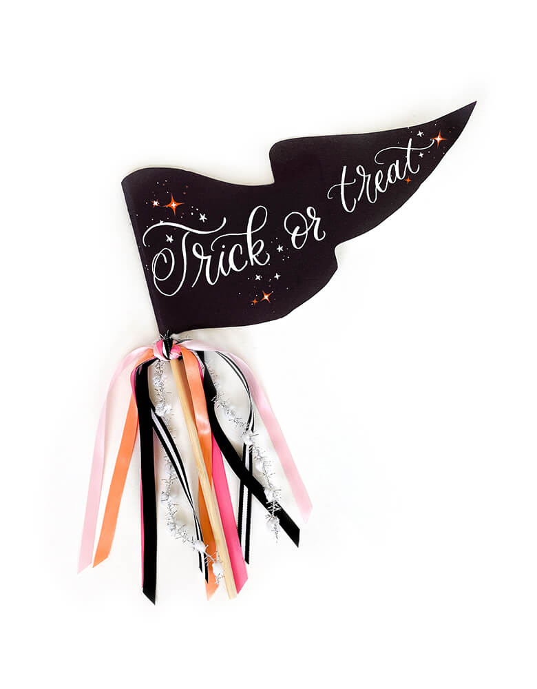 Trick or Treat Party Pennant by Cami Monet. This 10 x 5 inches handmade in classic black and white pennant featuring a handwriting "Trick or Treat" print with blinking stars on the 120 lb. luxe paper with original illustration for extra whimsy, and with mutily Ribbon and sparkle garland adding details on the rod. This high quality made party pennant is such a fun take on a classic halloween sign! perfect for celebrating Halloween!