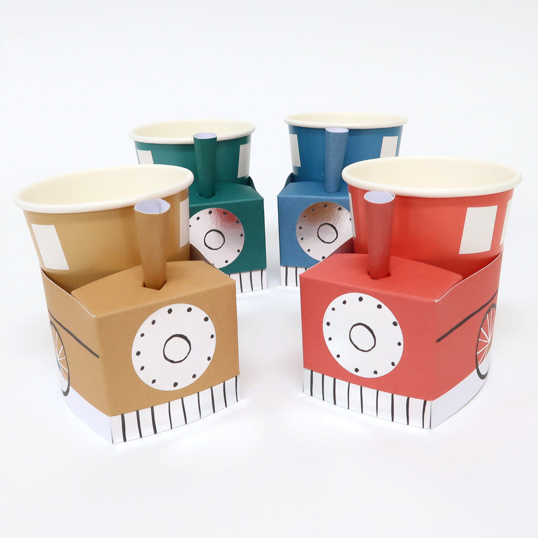 Momopartys 3D Train cups by Meri Meri. Pack of 8 in 4 colors of blue, red, yellow and green, at size 9 oz. capacity, they're perfect for kid's birthday party. Simple self assembly required. Cups are made of 3 easy-to-assemble pieces - cup, cup wrap and funnel