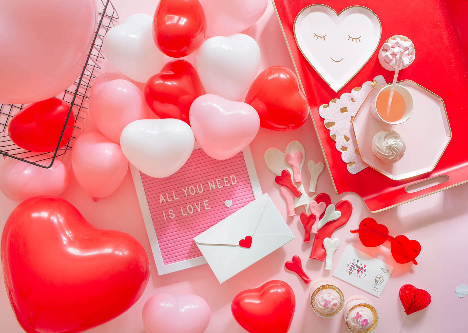 Valentine's Day Galentine's Party Ideas with Kids featuring heart-shaped latex balloons in pink, white and red and heart shaped plates in pink styled by Momopartys
