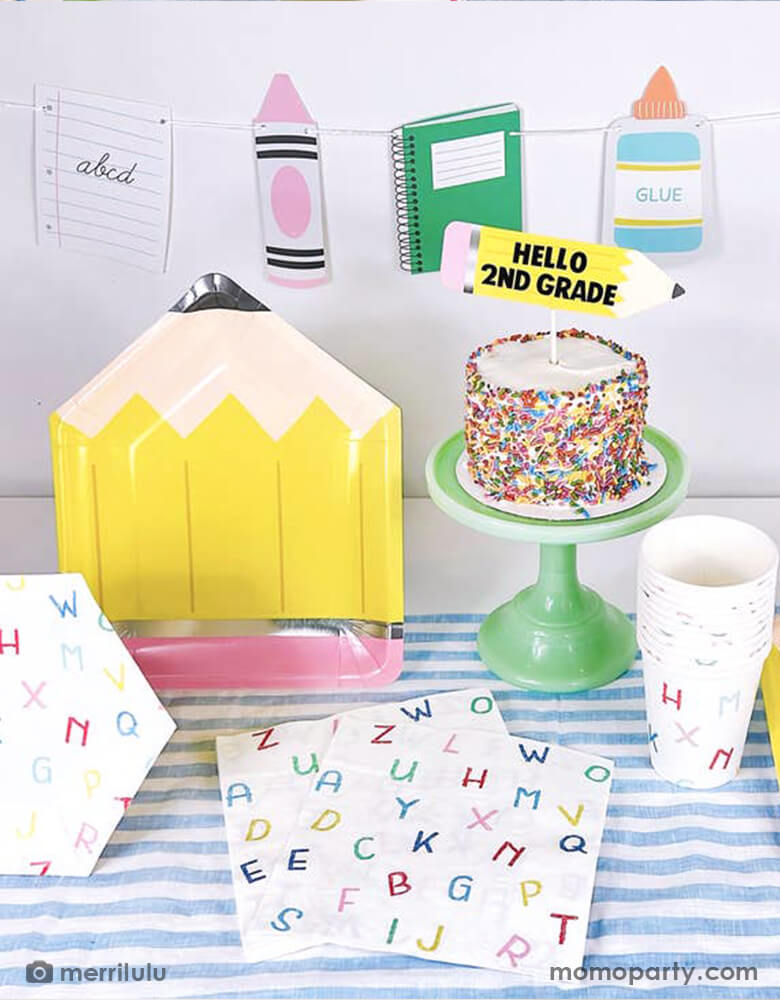A school themed party table filled with Momopartys's school themed party supplies including a pencil shaped plate, ABC alphabet patterned napkins, plates and cups. Next to the tableware there's a cake topped with a pencil shaped cake topper with "Hello 2nd Grade". In the back there's a back to school party banner featuring colorful school themed pennants including crayon, glue bottle, notebook and more. All this makes a great inspo for a back to school party or first day of school celebration.