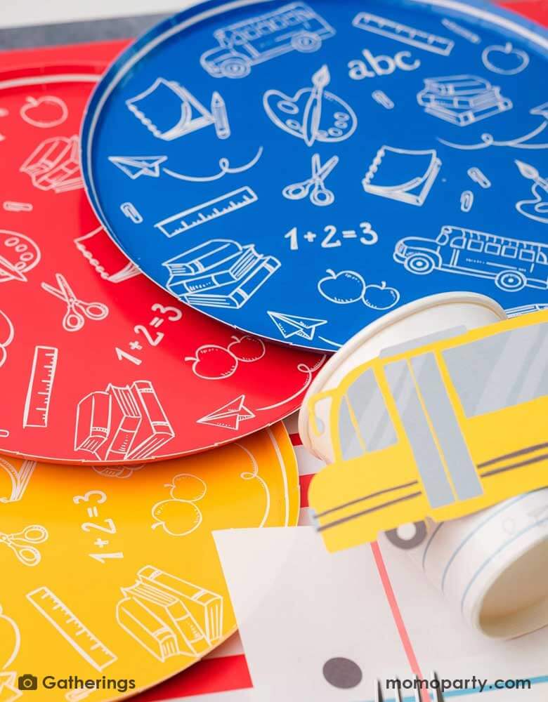 A close up of a back to school party featuring school themed party supplies from Momopartys including school day assorted side plates with school supply patterns in 4 colors of green, blue, red and yellow, with the No. 2 pencil patterned dinner plates and loose leaf paper placemats by Gatherings. A perfect place setting to celebration kid's or student's first day of schoo,