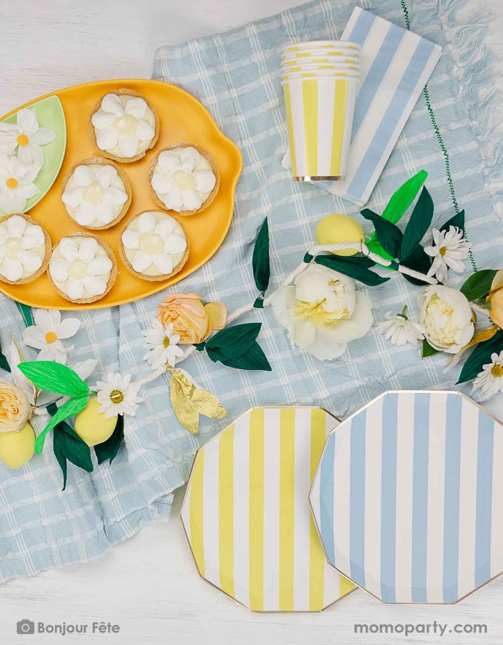 A stunning tableset in a Summer Party Capri Inspired party by Momopartys! Bursting with colors and textures, this stylish setting combines the vibrant striped aesthetics in yellow and sky blue of Capri with the refreshing citrus vibes of lemons and gingham checker patterns. Your guests will be transported to a picturesque seaside Italian village as they enjoy their summer feast underneath these enchanting decorations. 