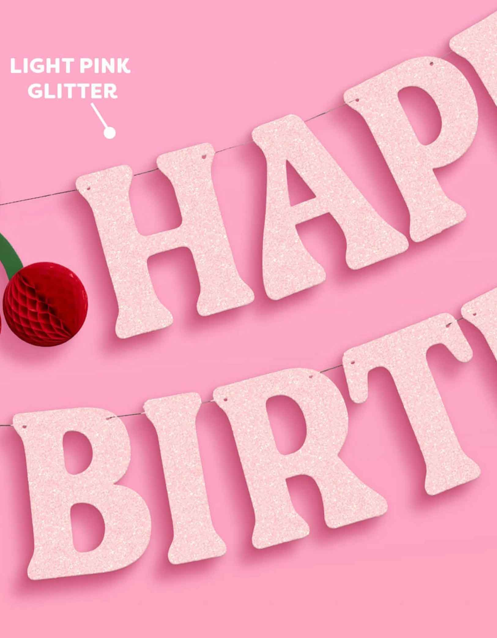 Momo Party's 4.5' cherry happy birthday banner in light pink glitter with cherry honeycomb decoration on a pink background.