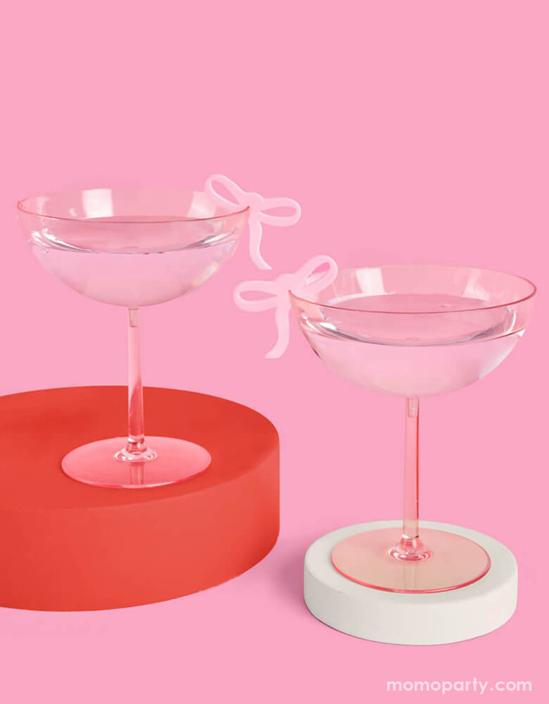 Two pink cocktail glasses adorned with Momopartys's coquette bow drink markers by Xo, Fetti on a modern drink display.  Whether it's a bday, bridal shower, or a bachelorette party, celebrate in bow bliss with these super cute drink markers. 