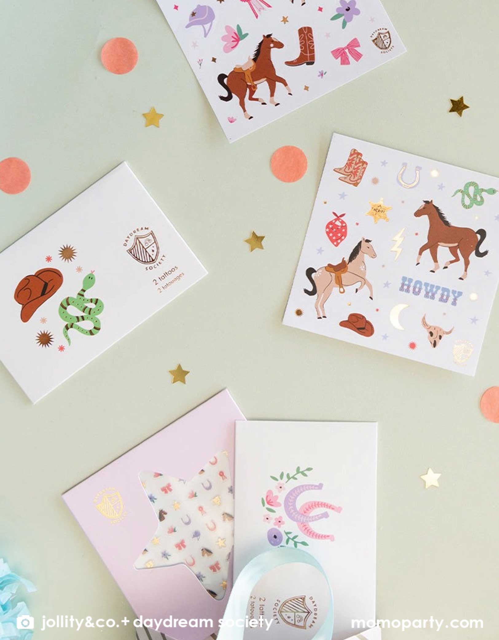 An overhead shot of Momopartys's Pony Tales Sticker Set, temporary tattoo sheets and Yeehaw cowboy temporary tattoos by Daydream Society. These temporary tattoo and stickers include images of horses, ribbons, florals and bows, cowboy hat, cowboy boots, horseshoes and snakes! They make the perfect birthday party favor or gift for a Western themed party or a horse/pony themed birthday bash!