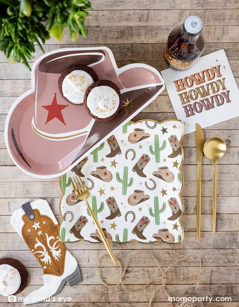 A Western rodeo themed cowboy themed party tablescape featuring Momopartys's cowboy themed party tableware including a cowboy hat shaped plate, the Howdy 5" small napkin and a cowboy patterned square large plate with cowboy boots, cactus, horseshoe and stars design, and a cowboy boot shaped napkin by My Mind's Eye. With matching colored treats and drinks, this makes a perfect inspiration for a Wester themed party or a kid's "First Rodeo" first birthday party.