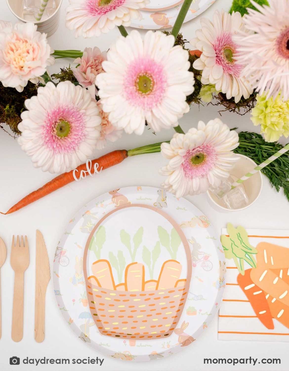 A overhead shot of a darling Easter-themed table setting with floral decorations, carrot basket shaped plates, carrot shaped napkins and matching utensils in a spring-inspired colors from Momopartys.