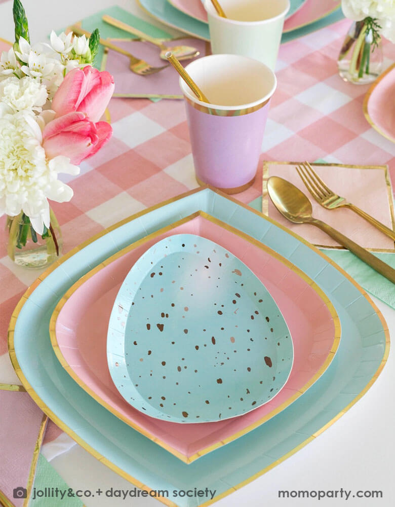 A spring inspired Easter party table placeset featuring Momopartys's pastel themed tableware including pastel mint & pink plates and robin egg shaped plates, lilac party cups, pink gingham table runner and gold utensils. With a spring floral bouquet, this makes a great tablescape for an Easter brunch table or a spring family and friends gathering. 