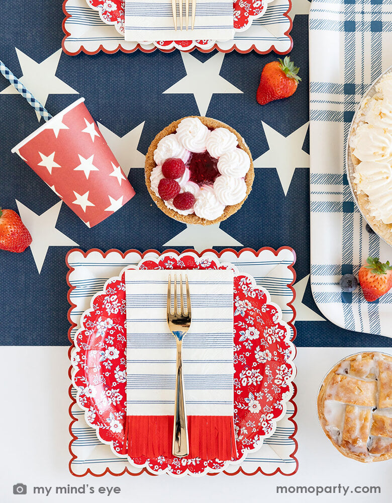 A festive patriotic theme tablescape featuring Momopartys's 9" navy and red scalloped stripe plates, red scalloped fringe guest napkins, 9 oz blue and red star party cups by My Mind's Eye. With raspberry pies and mixed berries served on the navy star pattern runner, all makes a festive and perfect inspiration for Memorial Day BBQ party or 4th of July Independence Day celebration.