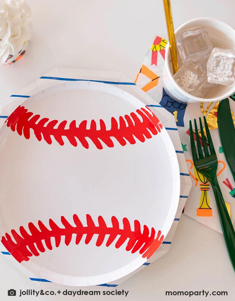 A sports themed party tablescape featuring Momopartys's 7.5 inch baseball plate layered on top of blue striped plates by Daydream Society. On the site there's 6-inch Good Sports large party napkins featuring sports themed illustration including trophies, number 1 fingers, metals, for a fun sports champion celebration!