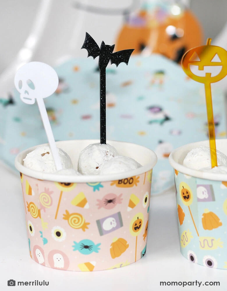 A couple of Halloween snack cups filled with donut walls topped with Momopartys's Halloween Monsters Mash acrylic food picks which feature a skull, a bat, a pumpkin and a ghost. They're perfect for kid's friendly Halloween celebration, a trick or treat party or a Halloween boothday!