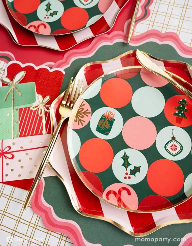 A festive Christmas party tablescape featuring Momopartys's Holiday tableware collection including red striped dinner plates and Christmas icon patterned side plates, along with gifts shaped napkins and red and green placemats, this makes a jolly table setting for this Holiday season.