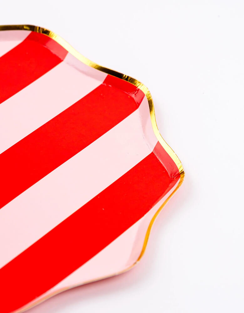 A close up shot of Momopartys's 10.5" Holiday Red Stripes Dinner Paper Plates by Gatherings. Comes in a set of 8 plates, made with eco-friendly FSC Mix paper, these vibrant and stylish plates with gold scallop edge are perfect for parties and dinners, making your tabletop a sight to behold. Create a festive atmosphere and elevate your dining experience with these plates!
