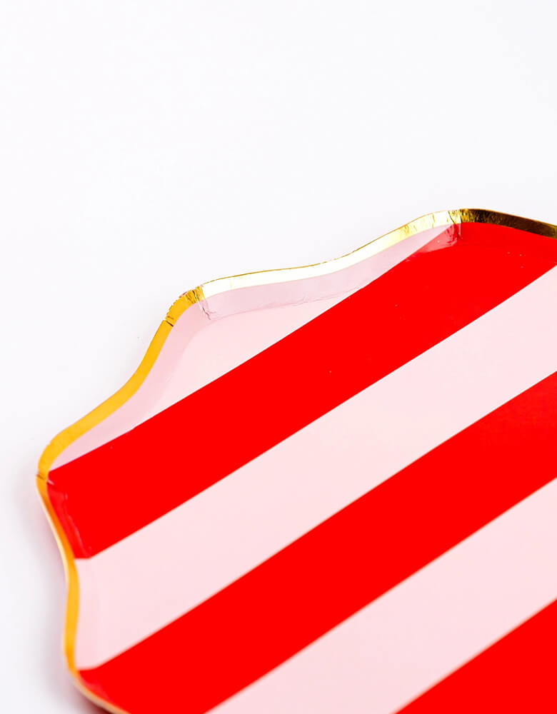A close up shot of Momopartys's 10.5" Holiday Red Stripes Dinner Paper Plates by Gatherings. Comes in a set of 8 plates, made with eco-friendly FSC Mix paper, these vibrant and stylish plates with gold scallop edge are perfect for parties and dinners, making your tabletop a sight to behold. Create a festive atmosphere and elevate your dining experience with these plates!
