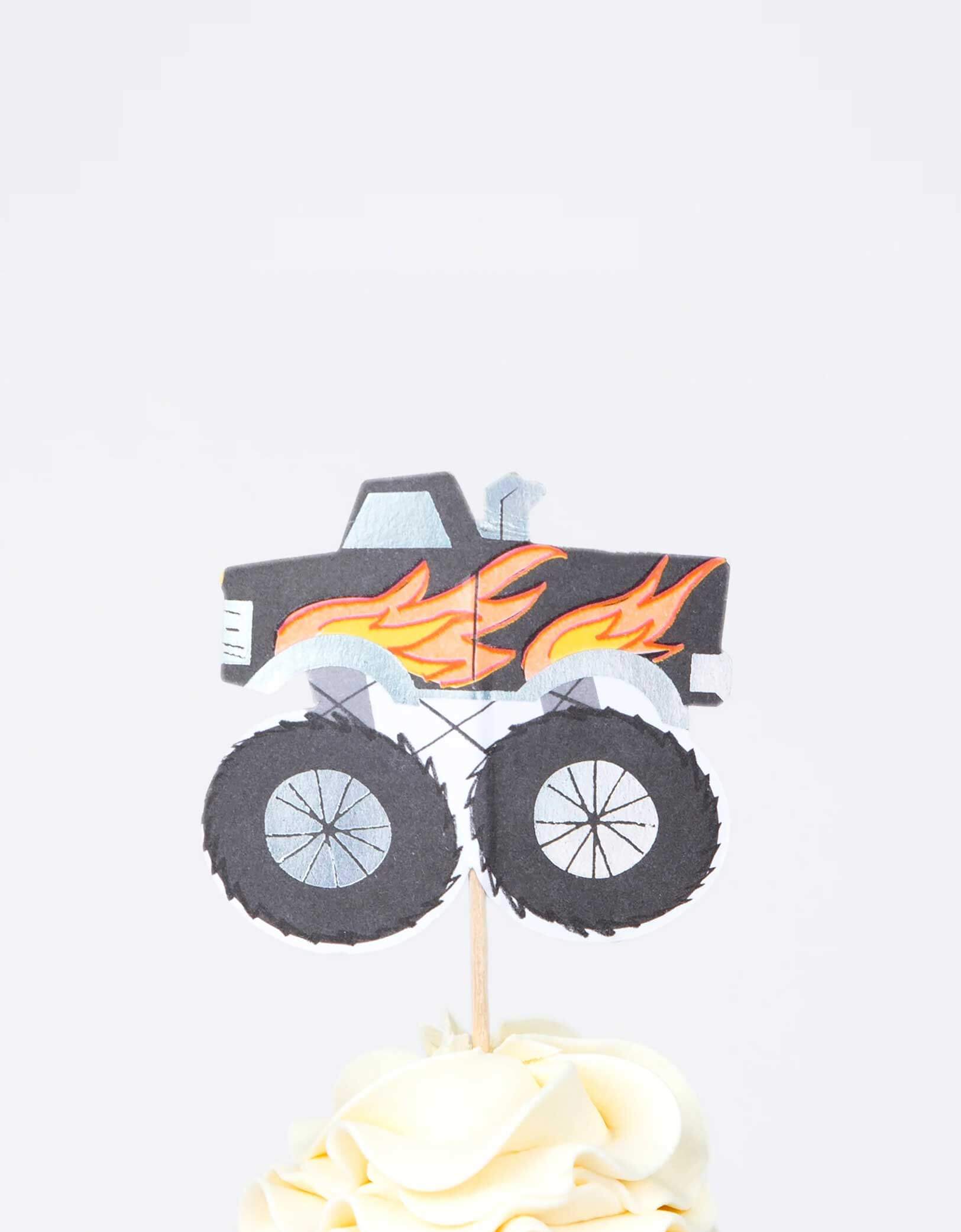 A cupcake decorated with Momopartys's Monster Truck cupcake topper by Meri Meri in black. This fun kit also makes a great gift for kids who love to bake.
