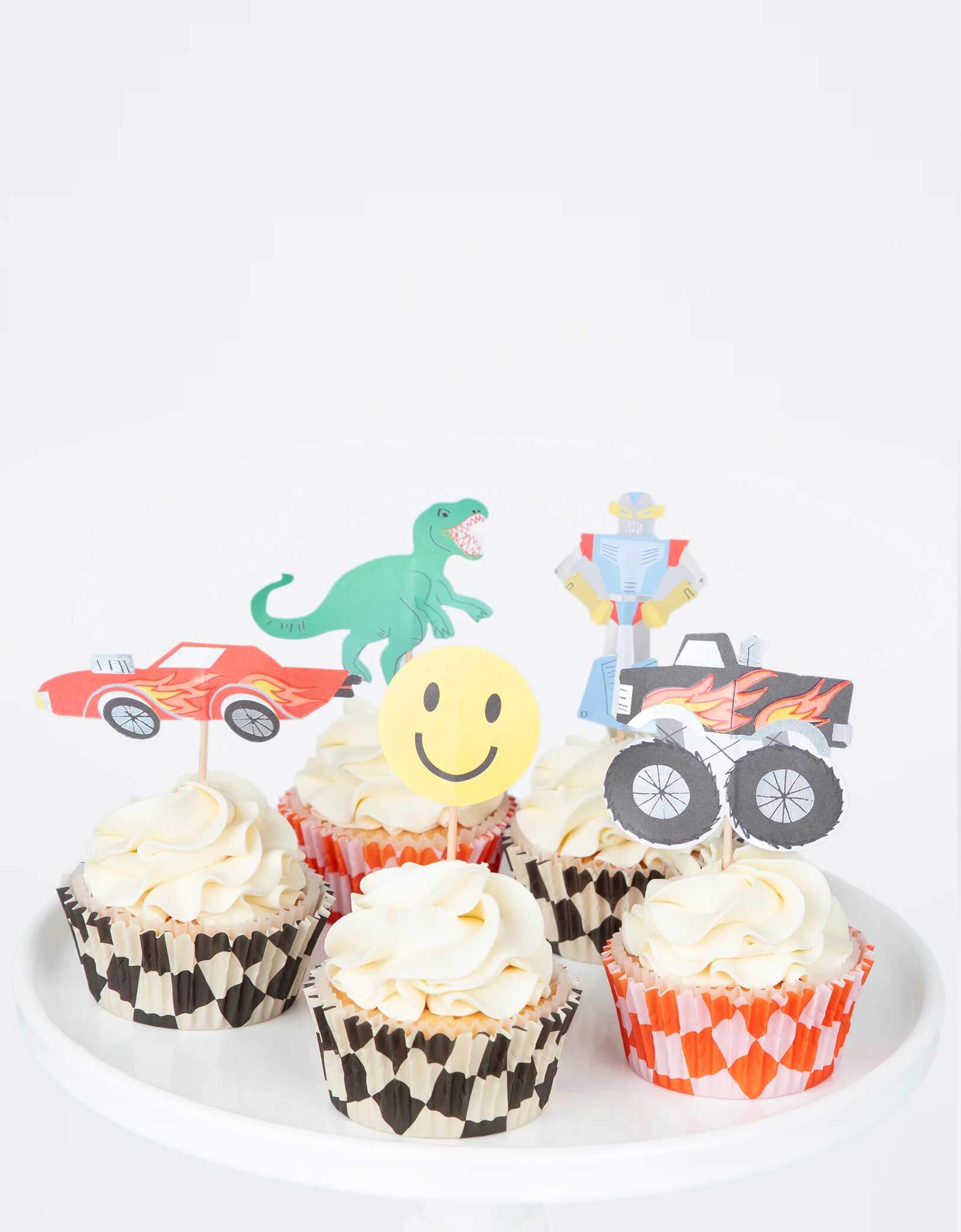 A few cupcakes decorated with Momopartys's Monster Truck Cupcake Kit by Meri Meri, featuring iconic retro toy cupcake toppers, including 5 designs of a monster truck, a car, a robot, a T-rex and a smiley face and checked cupcake cases, to make the most fun and tasty treats. This fun kit also makes a great gift for kids who love to bake.