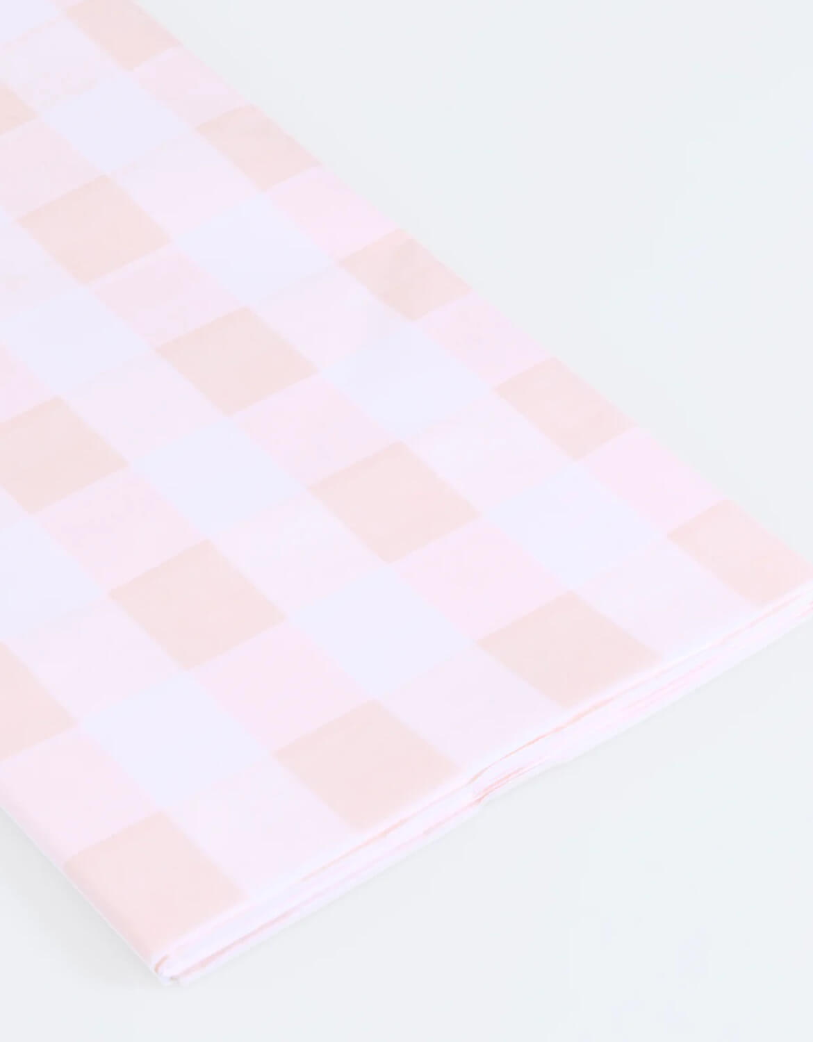 A close up of Momopartys's paper tablecloth with pink and white checkered design by Meri Meri on a white background.