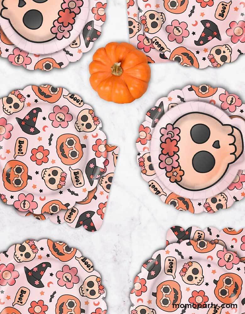 A fall Halloween party table featuring Momopartys's 8" Groovy Halloween Icon Plates, Floral skull plates and 6.5" Groovy Halloween Napkins by Ellie's Party. This collection is perfect for a cute and stylish Halloween table setting. Featuring groovy pumpkins, skulls, flowers, and witch hats, this party collection is great for a pink Halloween bash or kid's boho Halloween birthday party!