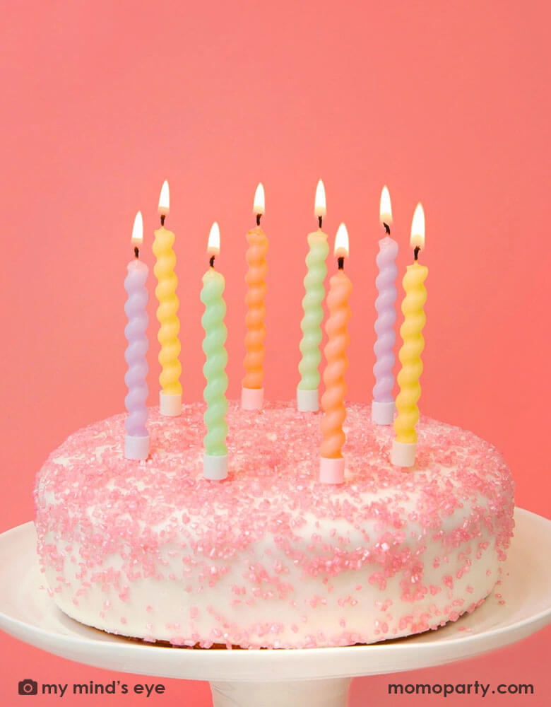 A birthday cake with pink sprinkles topped with Momopartys's Twisted Pastel Birthday Candles by Talking Tables. Comes in a set of 8, In 4 pastel colors with a fun twisted candle design, use on their own or pair with a cake topper for a special celebration. Perfect for a birthday cake, kids party, baby shower or an easter cake.
