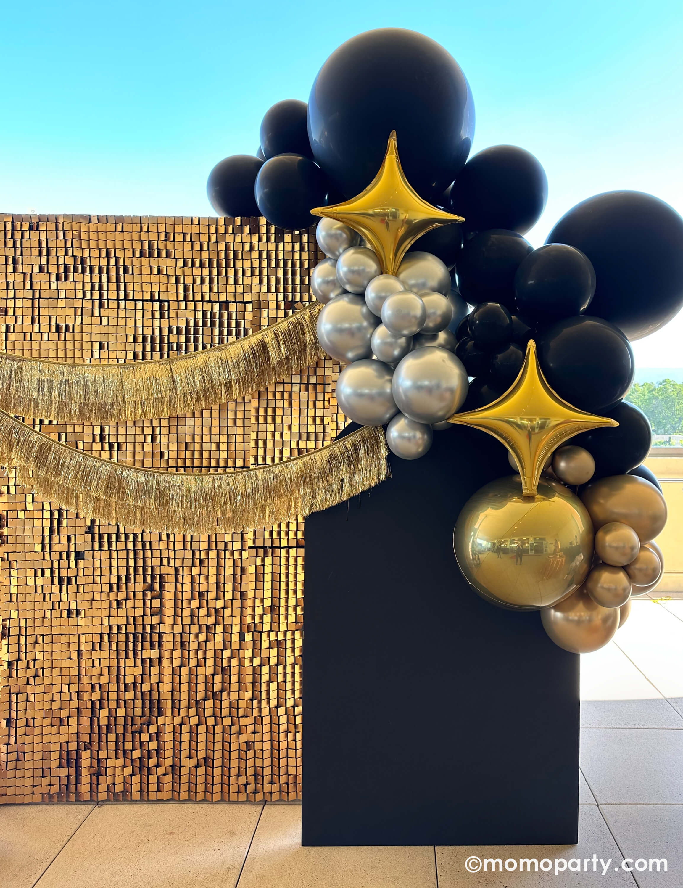 Presented by Momopartys, this luxe black, gold, and silver balloon garland with Large Gold Starpoint Foil Mylar Balloon, and a shimmering sequin backdrop and gold fringe accents is perfect for Hollywood parties, New Year’s Eve, auctions, and milestone celebrations. A bold, photo-worthy statement piece! 🎉✨






