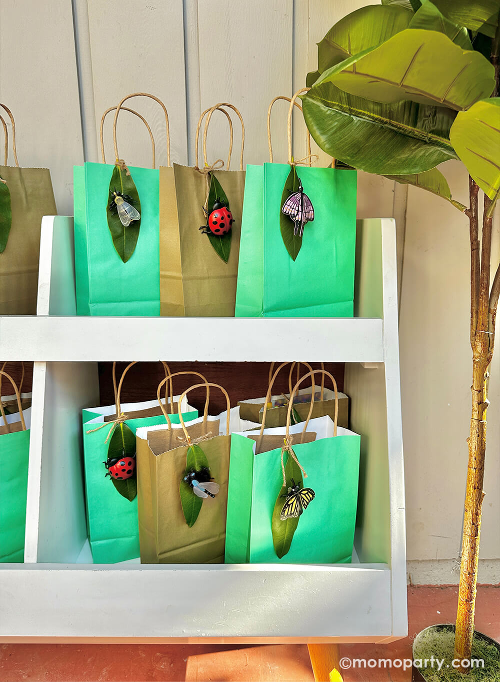 A diy project using Momopartys's various insect finger puppets and real leaves as decoration to party favor bags for kid's bug insect themed birthday party.
