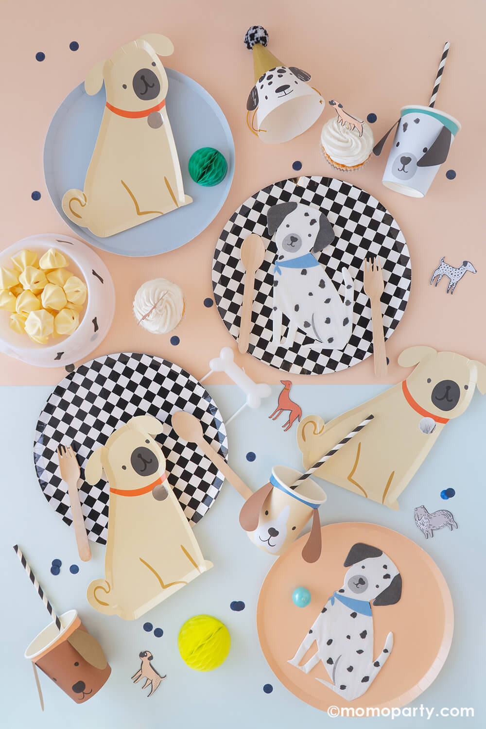 A soft color table with light blue and light peach colored tablecloth filled with Momopartys's dog themed party supplies including 10" black and white checkered round dinner plates, 8.5" x 9" pug dog shaped plates by Meri Meri, Dalmatian shaped napkins, 3D dog party cups and dog shaped party hats, along with yummy treats topped with dog themed cake toppers and bone shaped candle, it makes a great inspo for kid's puppy themed birthday party or a party for your four legged friend!