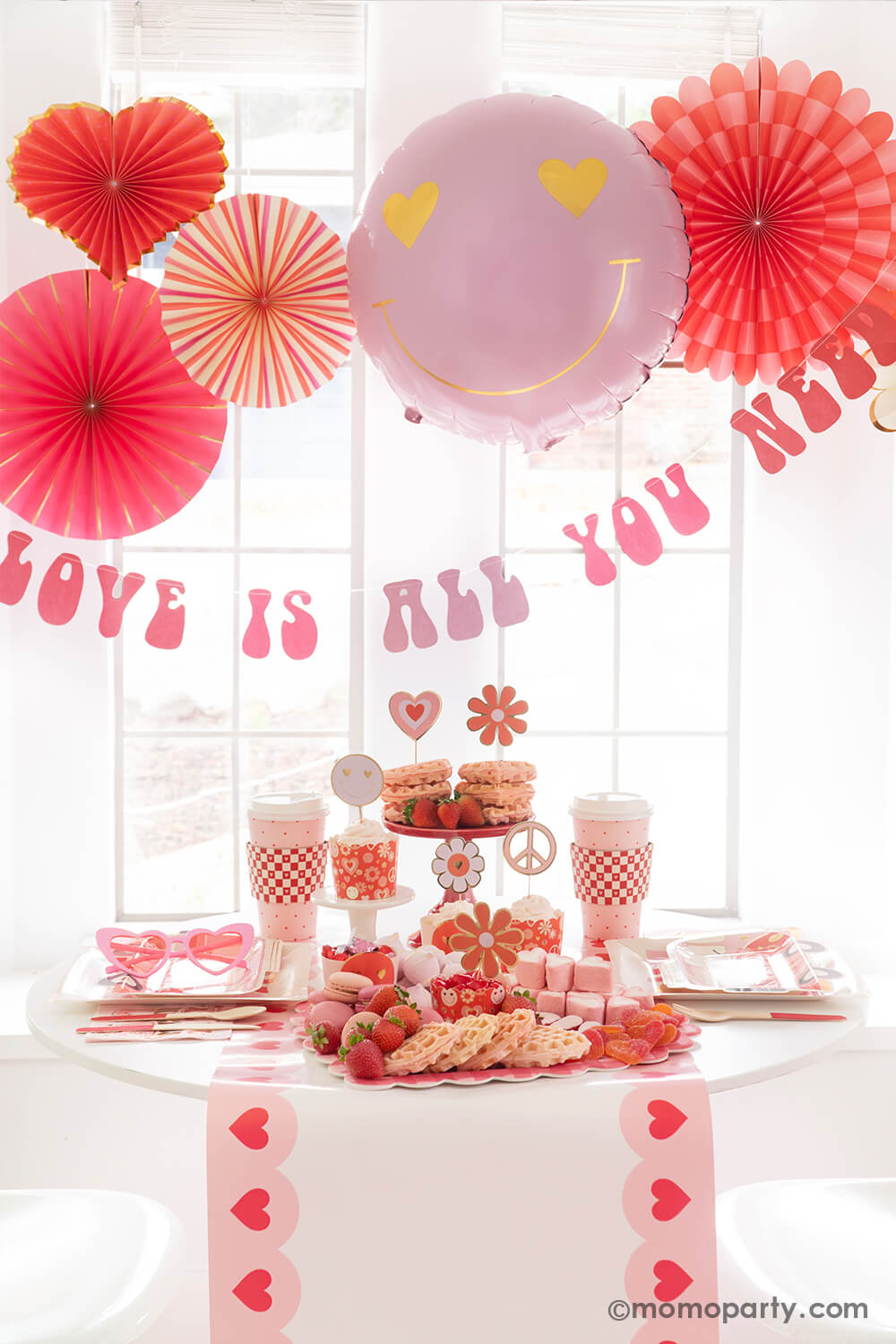 Momopartys presents the Groovy Valentine's Day Party Box, capturing a vintage vibe of love and peace with a groovy touch. This comprehensive kit includes My Mind's Eye Square Love Paper Plates, Luv Bus Paper Plates, All You Need is Love Napkins, Red Checks To-go Party Cups, Love Baking Cups With Toppers, Pink Heart Border Paper Table Runner, Heart You Paper Fan Set, Love Is All You Need Banner, and a Heart Eyes Love Foil Balloon. Perfect for throwing the ultimate Valentine's Day party