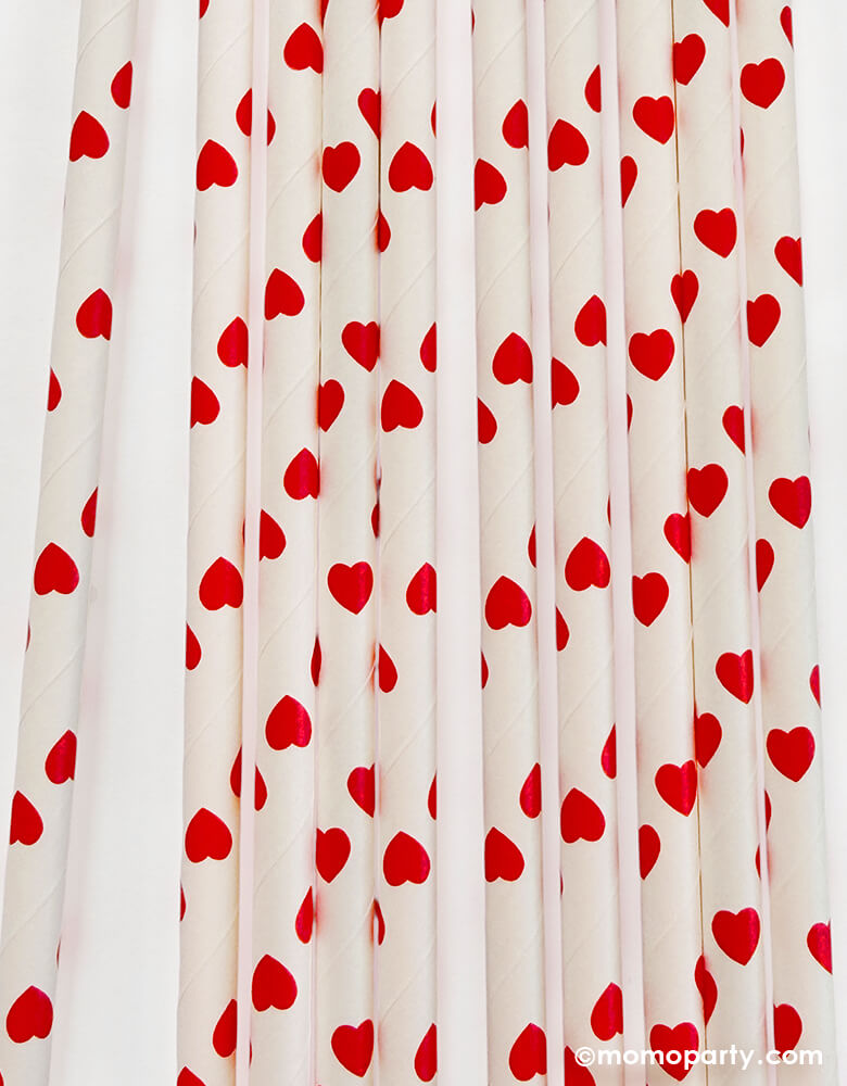 Details of Momopartys's eco friendly disposable paper party straws with red hearts pattern on a white background.