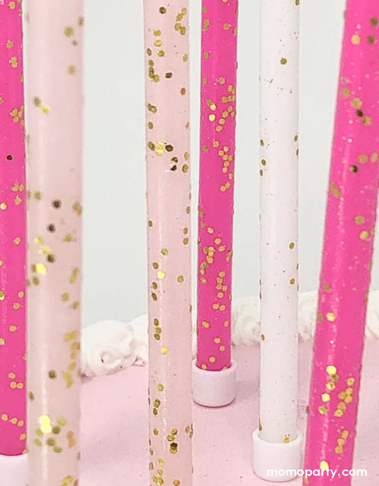 A closer look of the details of Momopartys's Pink Tones Gold Glitter Candle Set by Party Partners on the cake. This enchanting set features candles in light pink, hot pink, and white adorned with a touch of gold glitter. Complete with candle holders for seamless placement, these whimsical candles add a magical touch to any event. Ideal for princess party or girly celebrations of any kind, these candles bring a touch of elegance and charm.