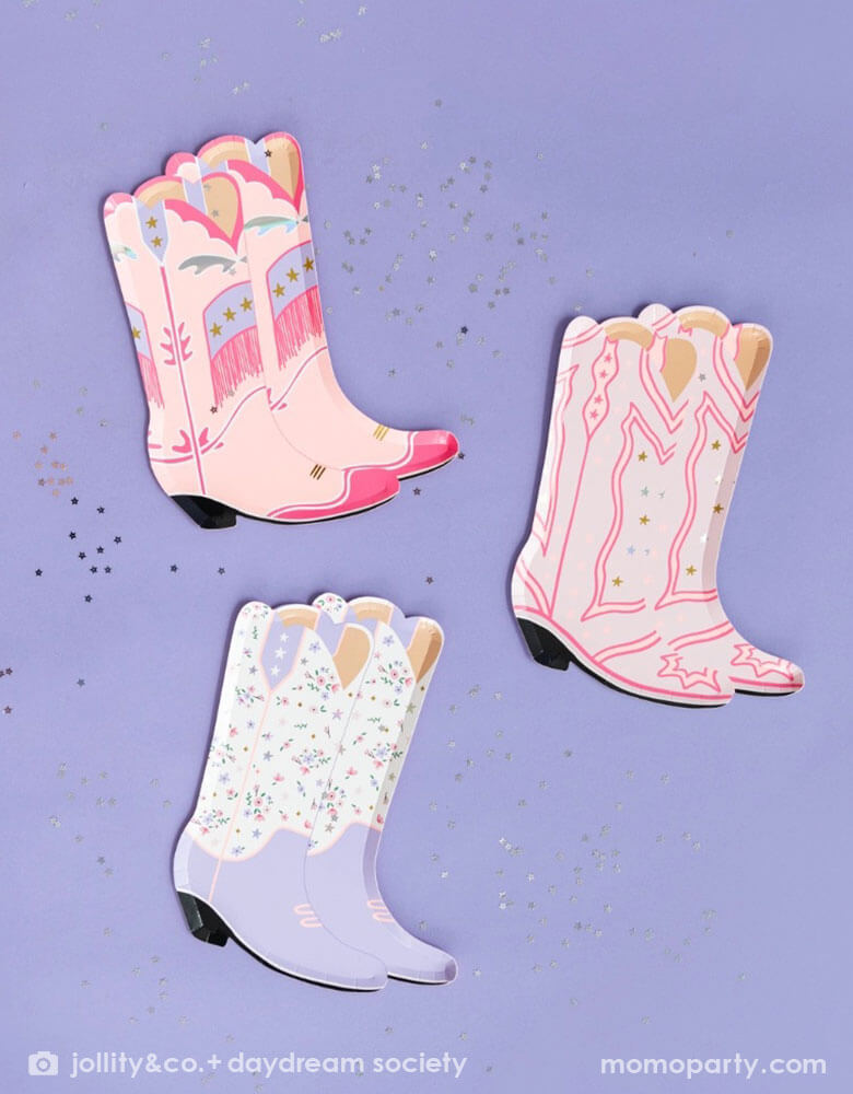 An overhead shot of Momopartys's 8" x 6" Pony Tales Large Boot Shaped Plates by Daydream Society on a purple background and confetti around. Comes in a set of 8 cowgirl boots shaped plates in 4 different designs and colors, these plates feature pink and purple boots trimmed with gold and silver foil details are perfect for a Western cowgirl themed party or girl's horse/pony themed birthday celebration.
