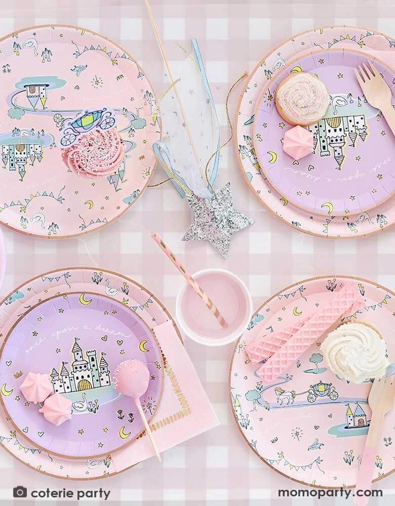 An adorable kid's princess table features Momopartys's 8.5' x 4.5' pink gingham tablecloth by Coterie. On the tablecloth there are some princess themed round paper plates with castles design on them, party cups and a glittered star wand. Making this a perfect inspo for a little girl's princess themed birthday celebration.